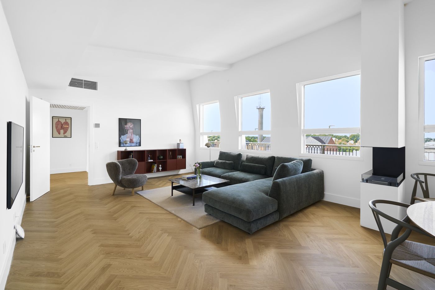 Furnished living room with green sofa in a serviced apartment in Odense